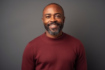 Medium shot portrait photography of a pleased Nigerian man in his 40s wearing a cozy sweater against an abstract background 