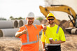 © Volodymyr - Construction site workers in a helmet work hard. Two workers in a hard hat is responsible for ensuring safety while constructing buildings. Builders workers personal protective equipment.