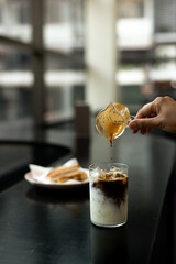 Sticker - Iced coffee with milk in a glass on a table in a cafe