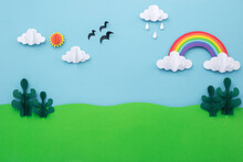 Paper Art Landscape Background. Blue Sky With Rainbow And Green Tree Made Of Paper Cut. Creative Minimal Concept.