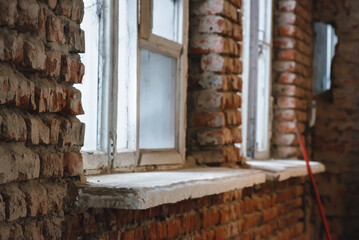 Old windows of abandoned building on the brick wall background.