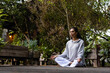 © Wavebreak Media - Biracial woman doing yoga, meditating on terrace in garden, copy space