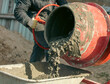 © schankz - Worker pouring concrete with cement mixer at construction site, closeup
