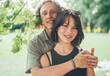 © Soloviova Liudmyla - Young teenage boy hugging his girlfriend cheerfully smiling at the camera during an outdoor walk in a summer city park. First love, modern teenagers relations concept image.