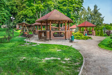 Picnic Area In Trostyanets Central Park, Sumy Oblast, Ukraine. Wooden Gazebos With Barbecues Among The Summer Greenery In The Town Garden