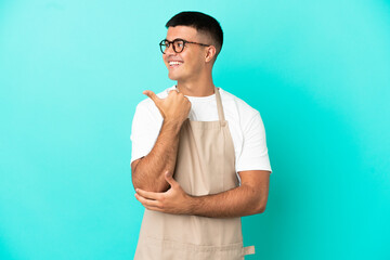 Wall Mural - Restaurant waiter man over isolated blue background pointing to the side to present a product