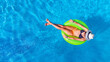 © Iuliia Sokolovska - Beautiful woman in hat in swimming pool aerial drone view from above, young girl in bikini relaxes and swims on inflatable ring donut and has fun in water on tropical vacation on holiday resort