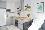 Fototapeta Sawanna - Scandinavian interior style modern studio small apartment in white and grey colors, furniture in living area and kitchen area
