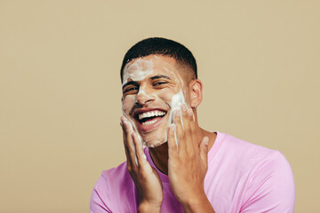 Wall Mural - Self-care and grooming, young man applying face wash