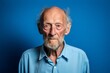 © Markus Schröder - Medium shot portrait photography of a tender old man wearing a casual short-sleeve shirt against a royal blue background. With generative AI technology