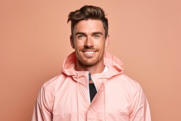 Canvas Print - Close-up portrait photography of a glad boy in his 30s wearing a lightweight windbreaker against a peachy pink background. With generative AI technology