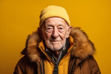Wall Mural - Close-up portrait photography of a glad old man wearing a warm parka against a bright yellow background. With generative AI technology