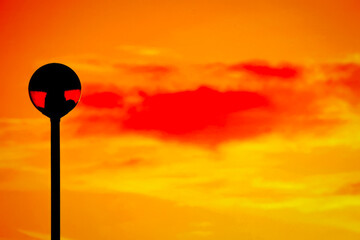 streetlamp in the foreground of a deep orange and red sunset