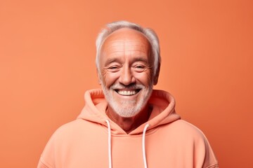 Wall Mural - Headshot portrait photography of a joyful mature man wearing a comfortable hoodie against a pastel orange background. With generative AI technology