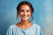 © Markus Schröder - Close-up portrait photography of a satisfied girl in her 20s wearing a simple tunic against a cerulean blue background. With generative AI technology
