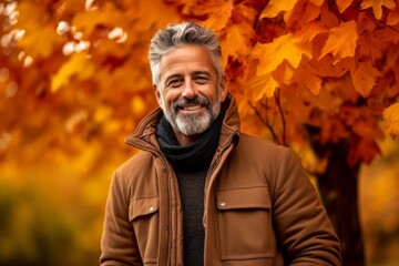 Wall Mural - Environmental portrait photography of a glad mature man wearing a warm parka against an autumn foliage background. With generative AI technology