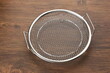 Stainless strainer cooling rack on wooden table
