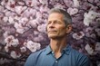© Markus Schröder - Photography in the style of pensive portraiture of a glad mature man wearing a casual t-shirt against a cherry blossom background. With generative AI technology