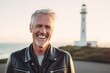 © Markus Schröder - Close-up portrait photography of a grinning mature man wearing a trendy leather jacket against a lighthouse background. With generative AI technology