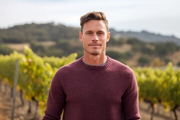 Poster - Close-up portrait photography of a satisfied boy in his 30s wearing a cozy sweater against a picturesque vineyard background. With generative AI technology