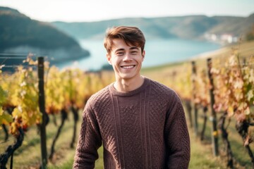 Wall Mural - Close-up portrait photography of a satisfied boy in his 30s wearing a cozy sweater against a picturesque vineyard background. With generative AI technology