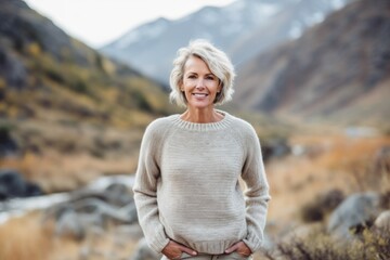 Wall Mural - Urban fashion portrait photography of a glad mature girl wearing a cozy sweater against a scenic mountain trail background. With generative AI technology