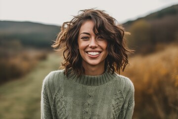 Wall Mural - Eclectic portrait photography of a grinning girl in her 30s wearing a cozy sweater against a picturesque countryside background. With generative AI technology
