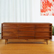 Classic mid-century modern dresser. Vintage wooden bedroom furniture. Interior view with white curtains and decor. 