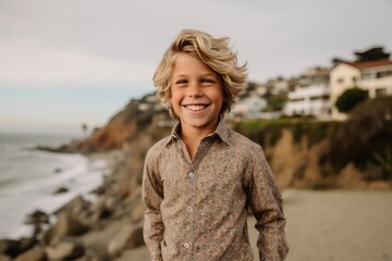 Wall Mural - Lifestyle portrait photography of a grinning kid male wearing a chic jumpsuit against a scenic coastal village background. With generative AI technology