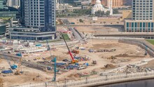 Pile Driving In Foundation Pit For Construction Of Apartment Complex Building Aerial Timelapse. Deep Installation And Excavation With Excavators, Cranes, Bulldozers And Trucks, Dubai Business Bay
