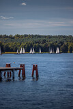Fototapeta Desenie - Sailboats on Ukiel lake in Olsztyn. In the foreground, the pier at the city beach
