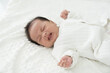 © amorn - Newborn baby crying on blanket on white bed. Family, love and new life concept