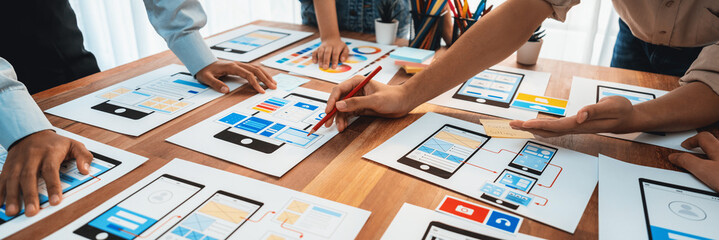 Poster - Panorama shot of front-end developer team brainstorming UI and UX designs for mobile app on paper wireframe interface. User interface development team planning for user-friendly UI design. Scrutinize