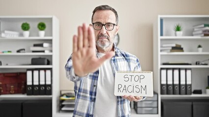 Sticker - Middle age man business worker holding stop racism notebook at office