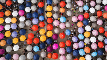 Background Of Defocused And Blurred Crowd Of People Under Umbrellas