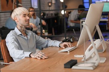 Male programmer working with computer in office at night