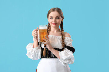 Beautiful Octoberfest waitress with beer on blue background