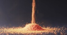 Video Of Close Up Of Orange Sand Grains Pouring Into Heap And Copy Space On Black Background