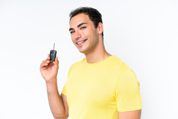 Wall Mural - Young caucasian man holding car keys isolated on white background smiling a lot