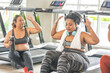 two plus size women in sports bras sitting on the treadmill hand clapping with friends greeting Let's talk about weight loss and exercising in the gym.
