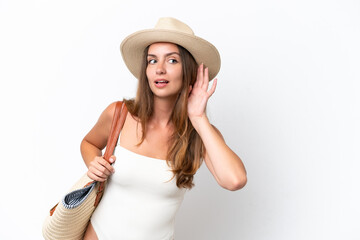 Wall Mural - Young caucasian woman in swimsuit in summer holidays isolated on white background listening to something by putting hand on the ear