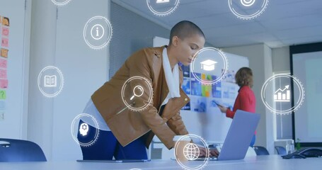 Poster - Animation of network of connections with icons over biracial businesswoman using laptop