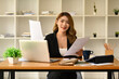© Prathankarnpap - Gorgeous asian female company worker or manager using laptop and working with financial document