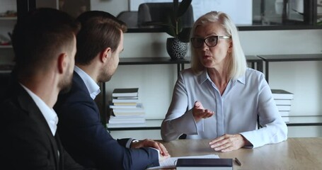 Canvas Print - Young businessman consulting senior professional leader woman, listening to advice of mature business expert, shaking hand, thanking for help, support, cooperation, partnership