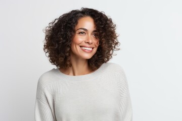 Portrait of beautiful young woman with curly hair smiling at camera.