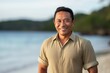 © Robert MEYNER - Portrait of a smiling asian man standing on the beach at sunset