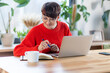 © leszekglasner - Short haired woman working on dining table as home office desk
