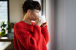 © leszekglasner - Short haired woman drinking hot coffee in her modern living room
