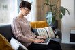 © leszekglasner - Relaxed woman using laptop sitting on sofa home