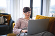 © leszekglasner - Relaxed woman using laptop sitting on sofa home